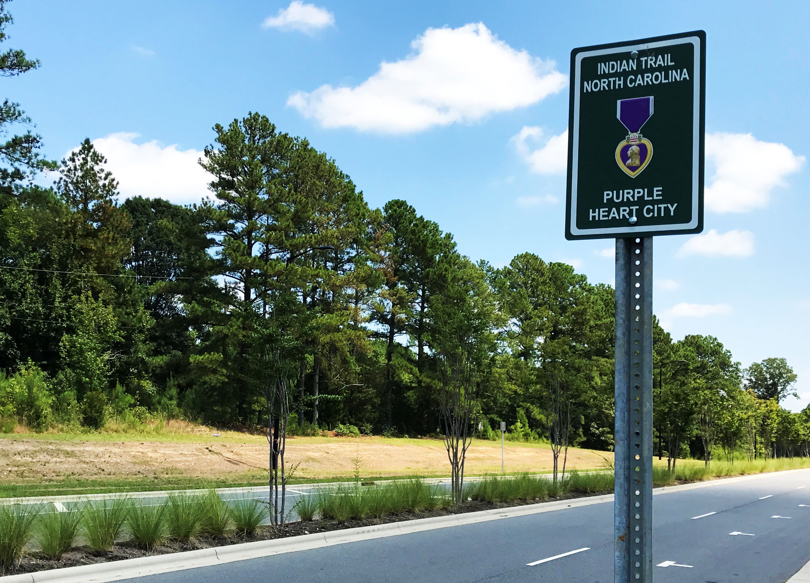 A Purple Heart City sign on Chestnut Parkway. Signs have been posted across Indian Trail marking the