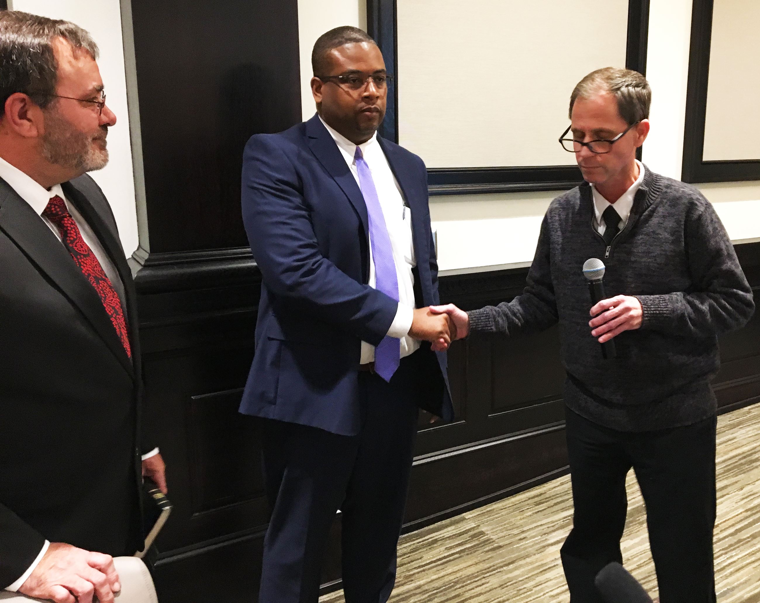 Marcus McIntyre (center) is sworn in with the help of Mayor Michael Alvarez (right) and Councilman J