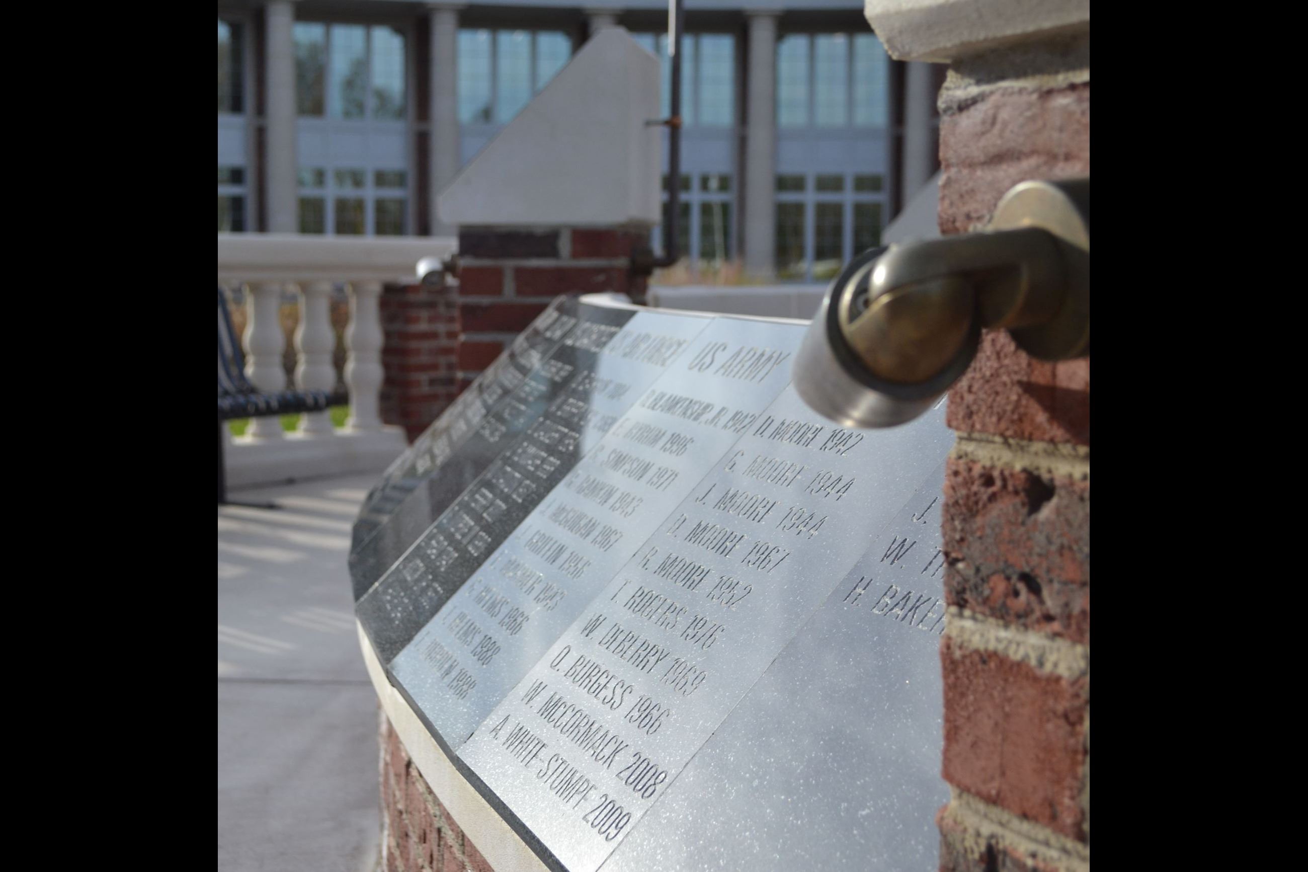 A close up side view of the engravings on the Veterans Memorial. The names are etched in black stone